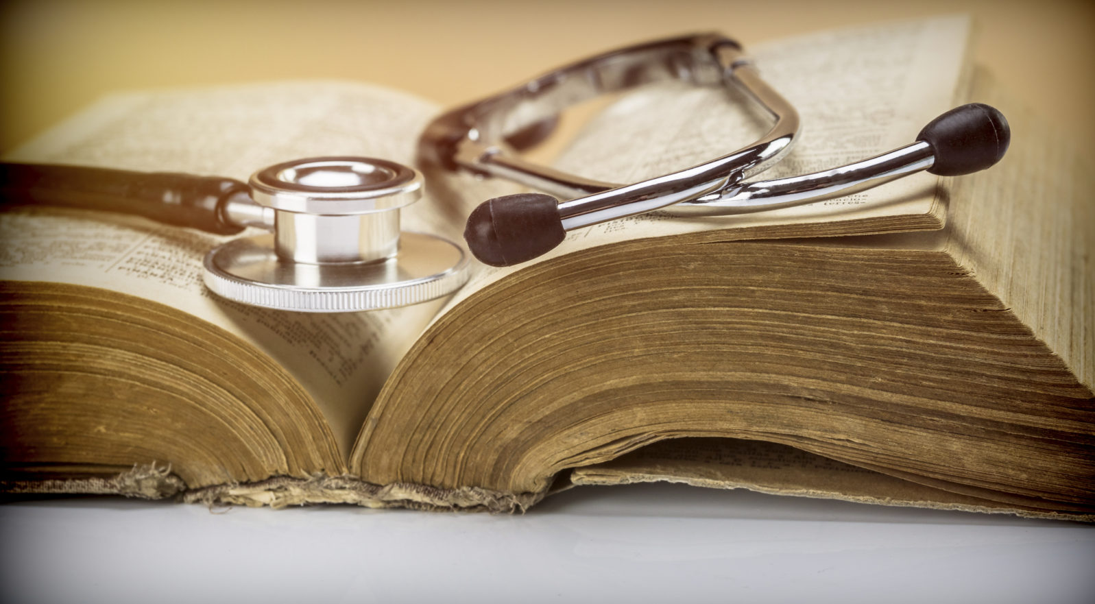 Stethoscope on an old book of medicine, conceptual image