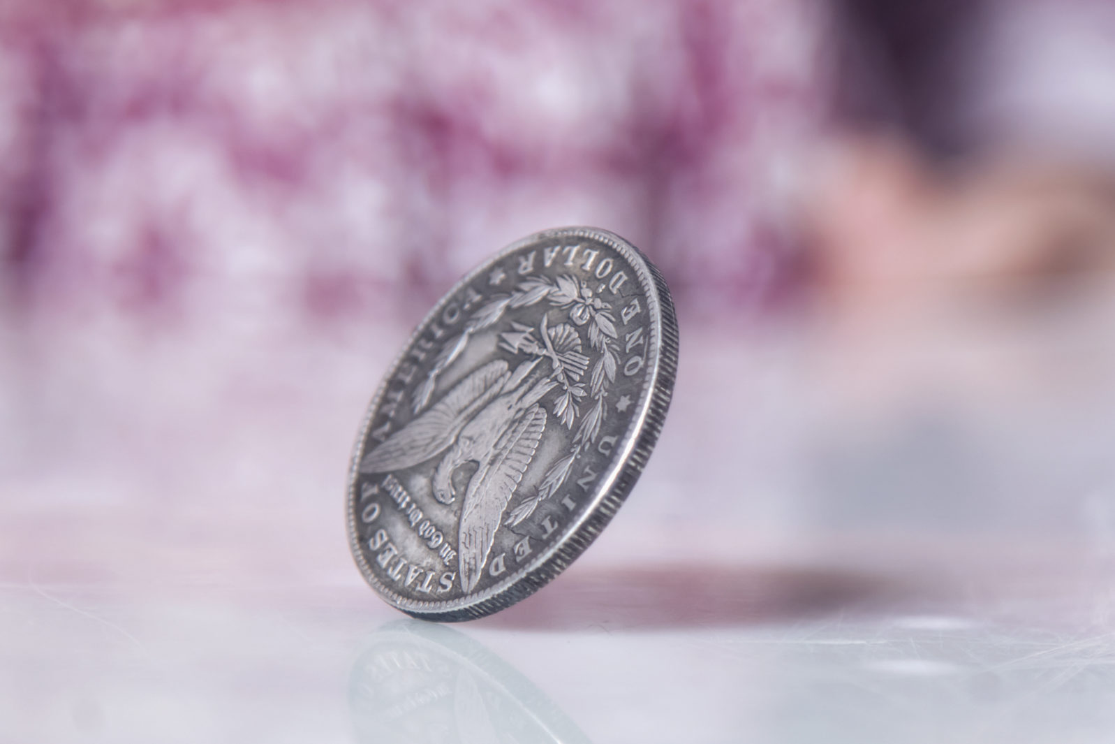 Close up cute little child girl spinning a coin to make decision. Heads or tails game.